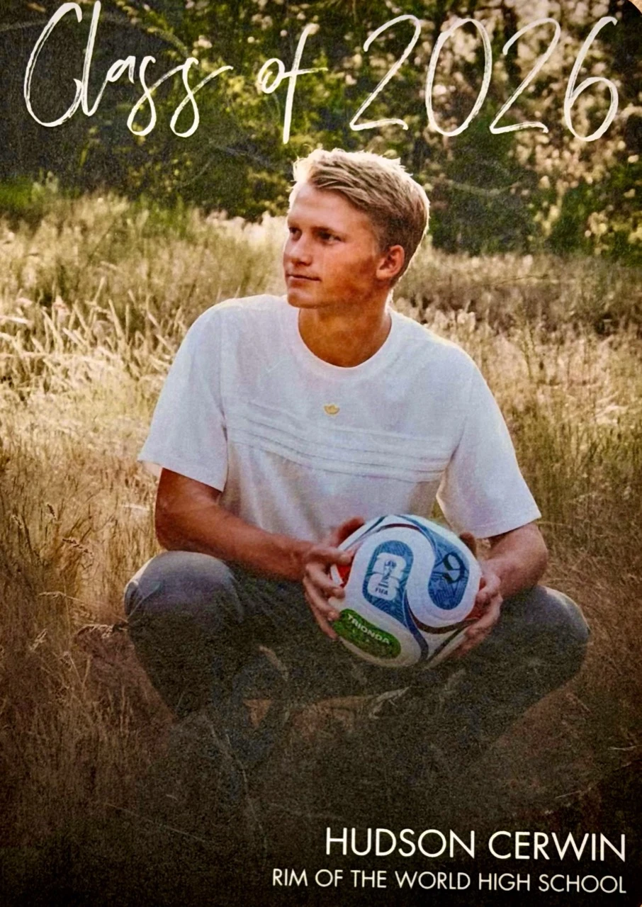 Hudson Cerwin, the 2025 scholarship recipient, seated outdoors holding a soccer ball.